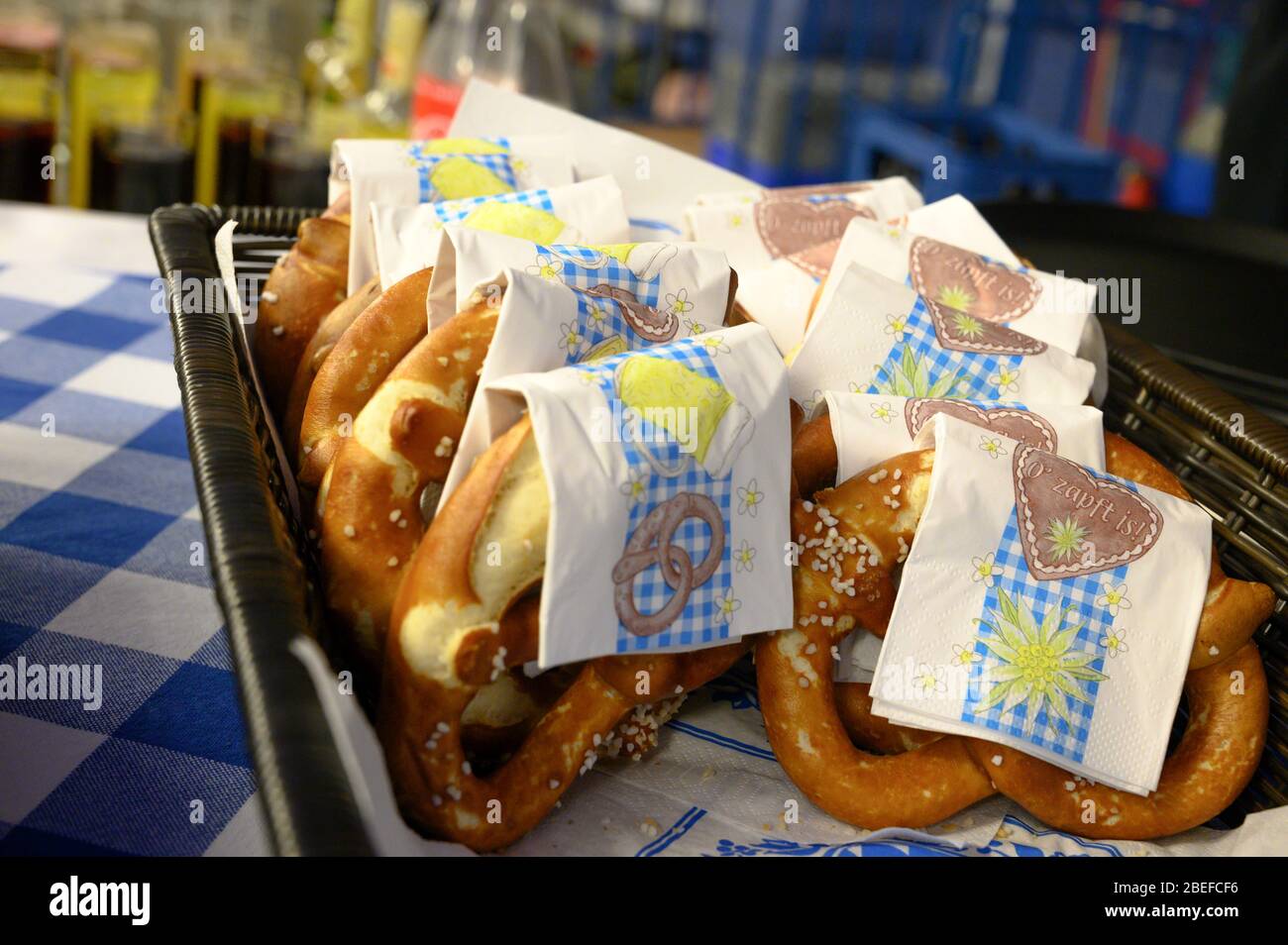 A stack of Bavarian pretzels on a blue checkered table at an Oktoberfest celebration in Germany, Europe, Bavaria Stock Photo