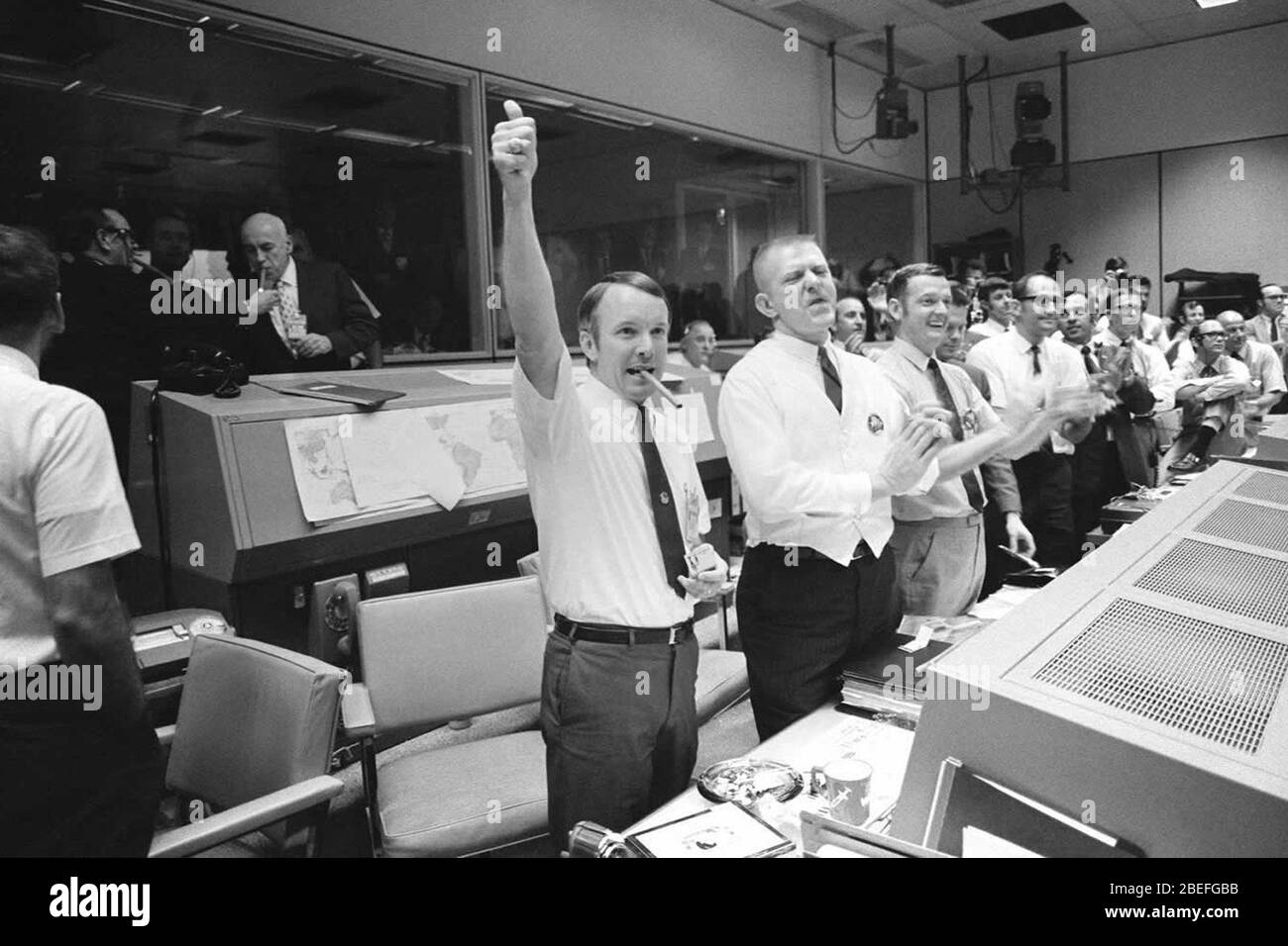 Three of the four Apollo 13 Flight Directors applaud the successful splashdown of the Command Module 'Odyssey.' At the same time, Dr. Robert R. Gilruth, Director, Manned Spacecraft Center (MSC), and Dr. Christopher C. Kraft Jr., MSC Deputy Director, light up cigars (upper left). The Flight Directors are from left to right: Gerald D. Griffin, Eugene F. Kranz, and Glynn S. Lunney. Apollo 13, launched on April 11, 1970, was NASA's third crewed mission to the moon. Two days later, on April 13, while en route to the lunar surface, a fault in the electrical system of one of the Service Module's oxyg Stock Photo