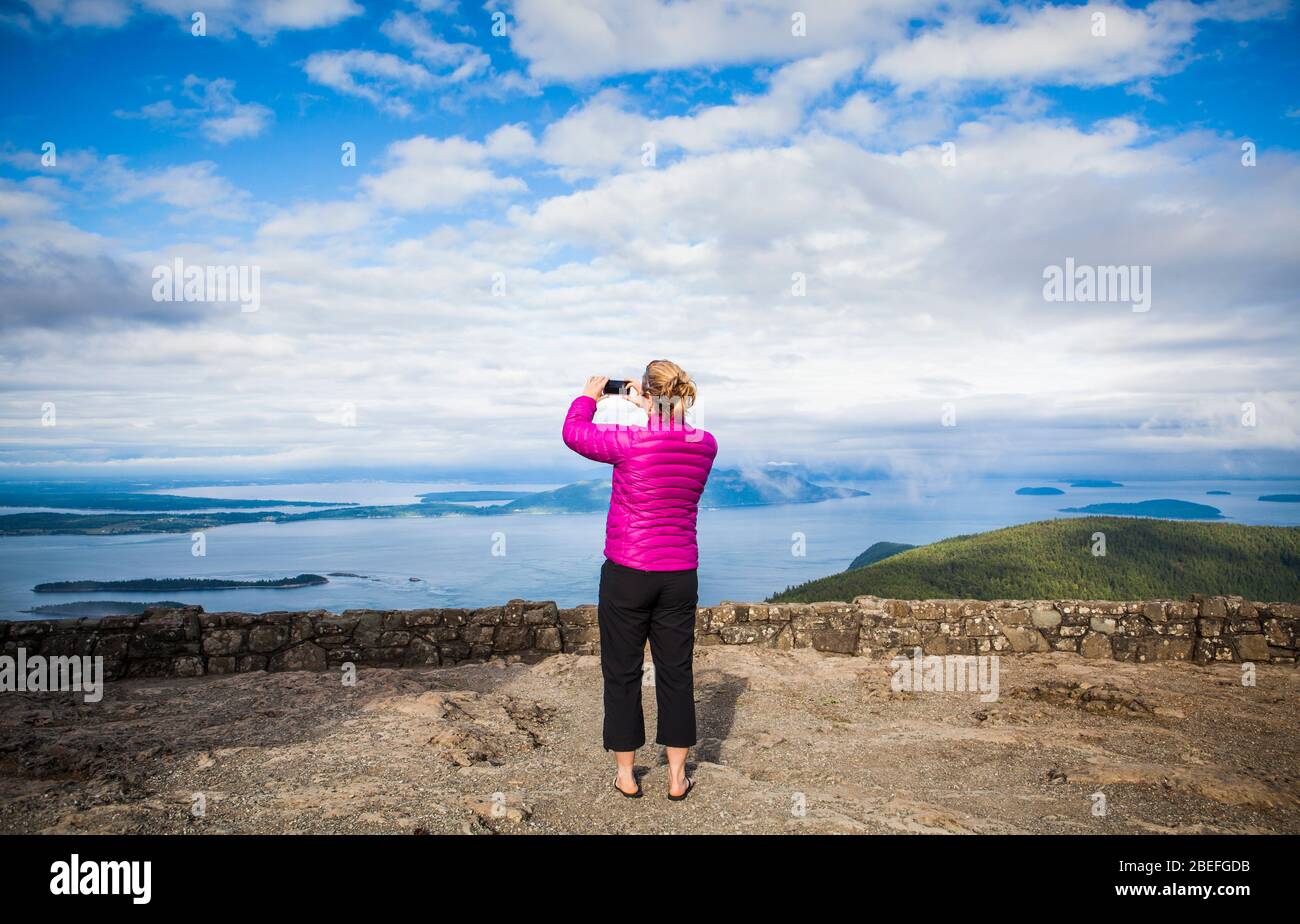 A woman taking pictures at the top of Mount Constitution on Orcas Island, Washington, USA. Stock Photo