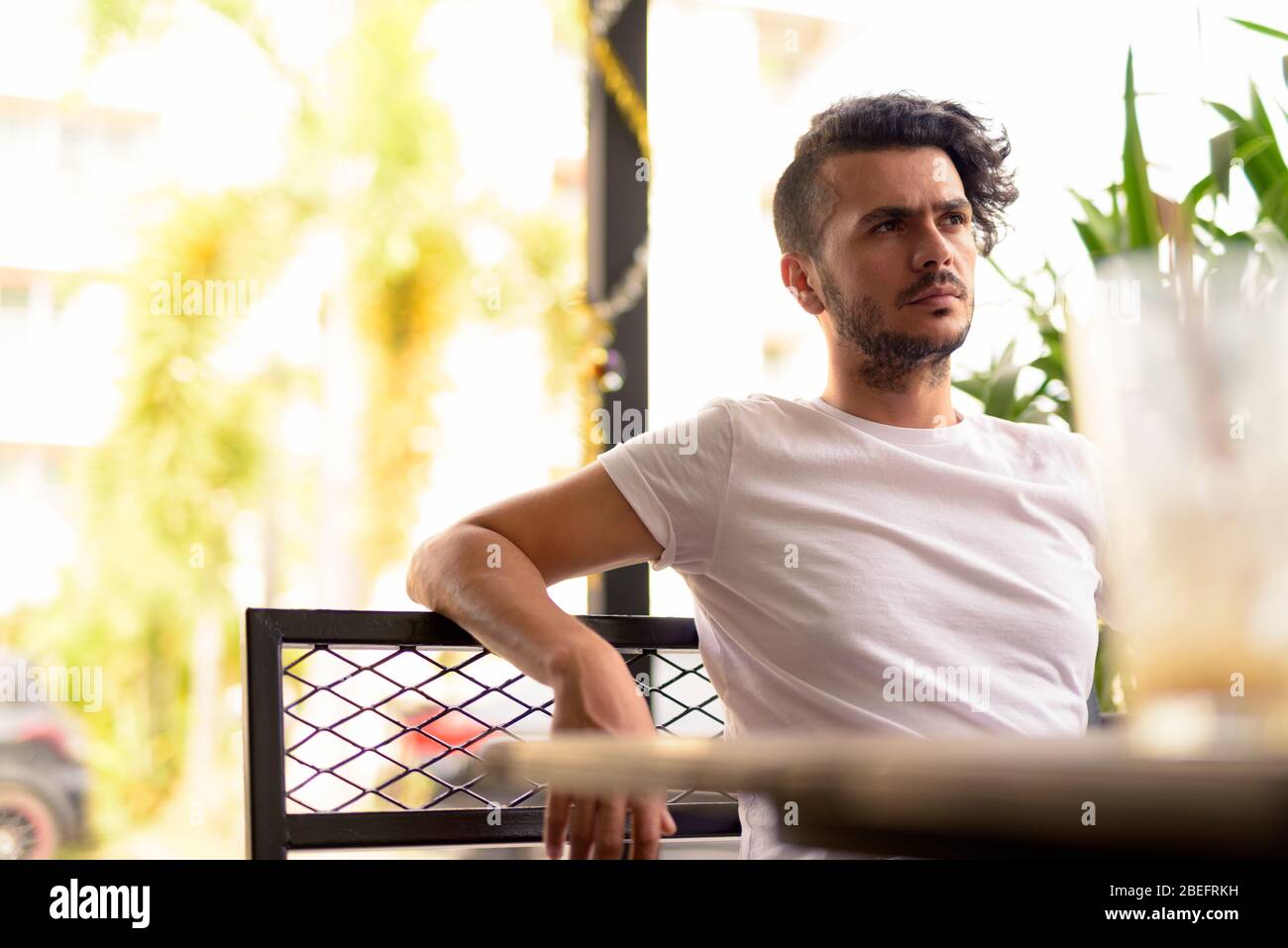 Handsome Turkish man with curly hair relaxing at the coffee shop Stock Photo