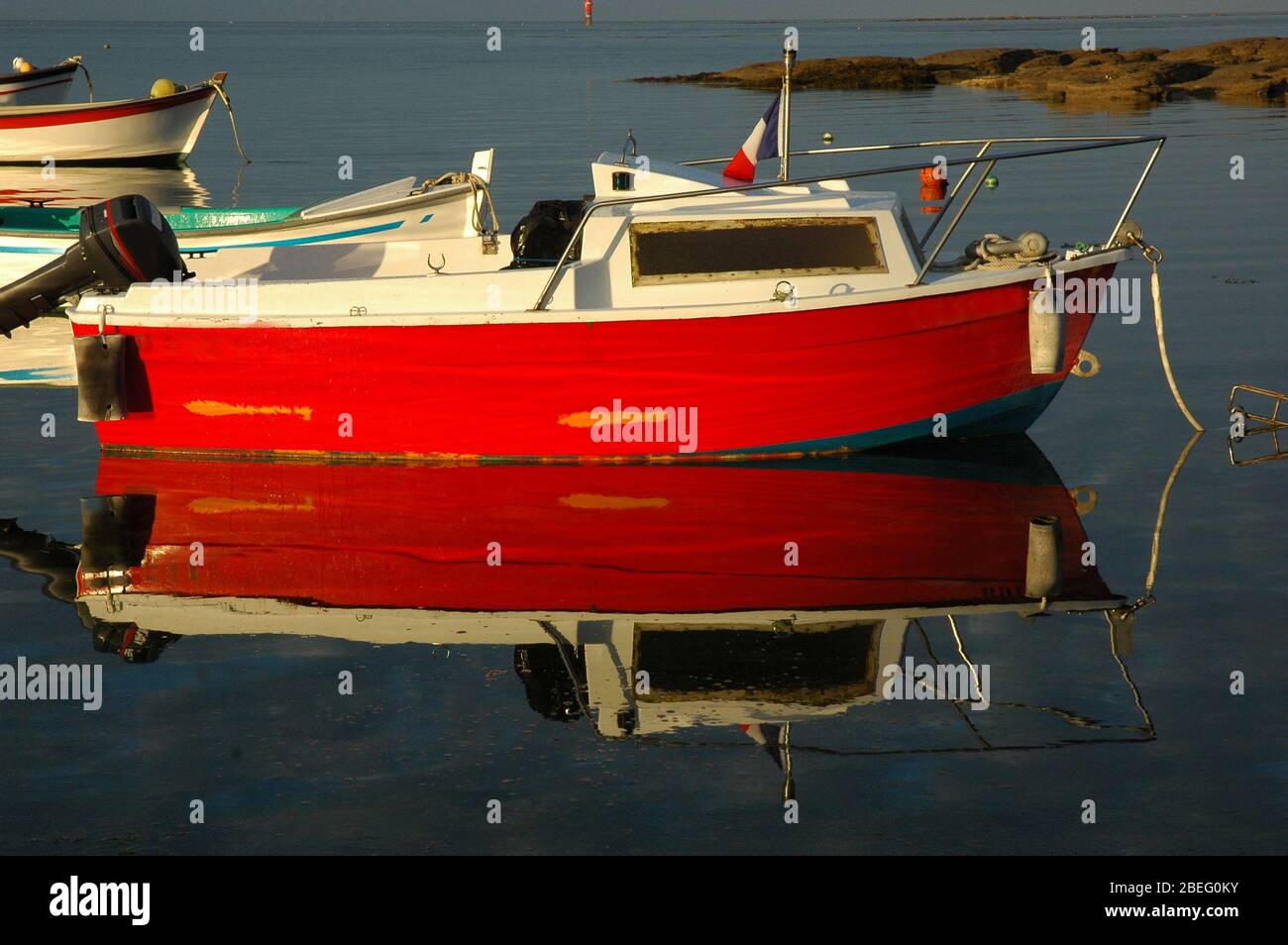 A red fishing boat is floating on the Atlantic ocean in Guilvinec, Fench Brittany Stock Photo