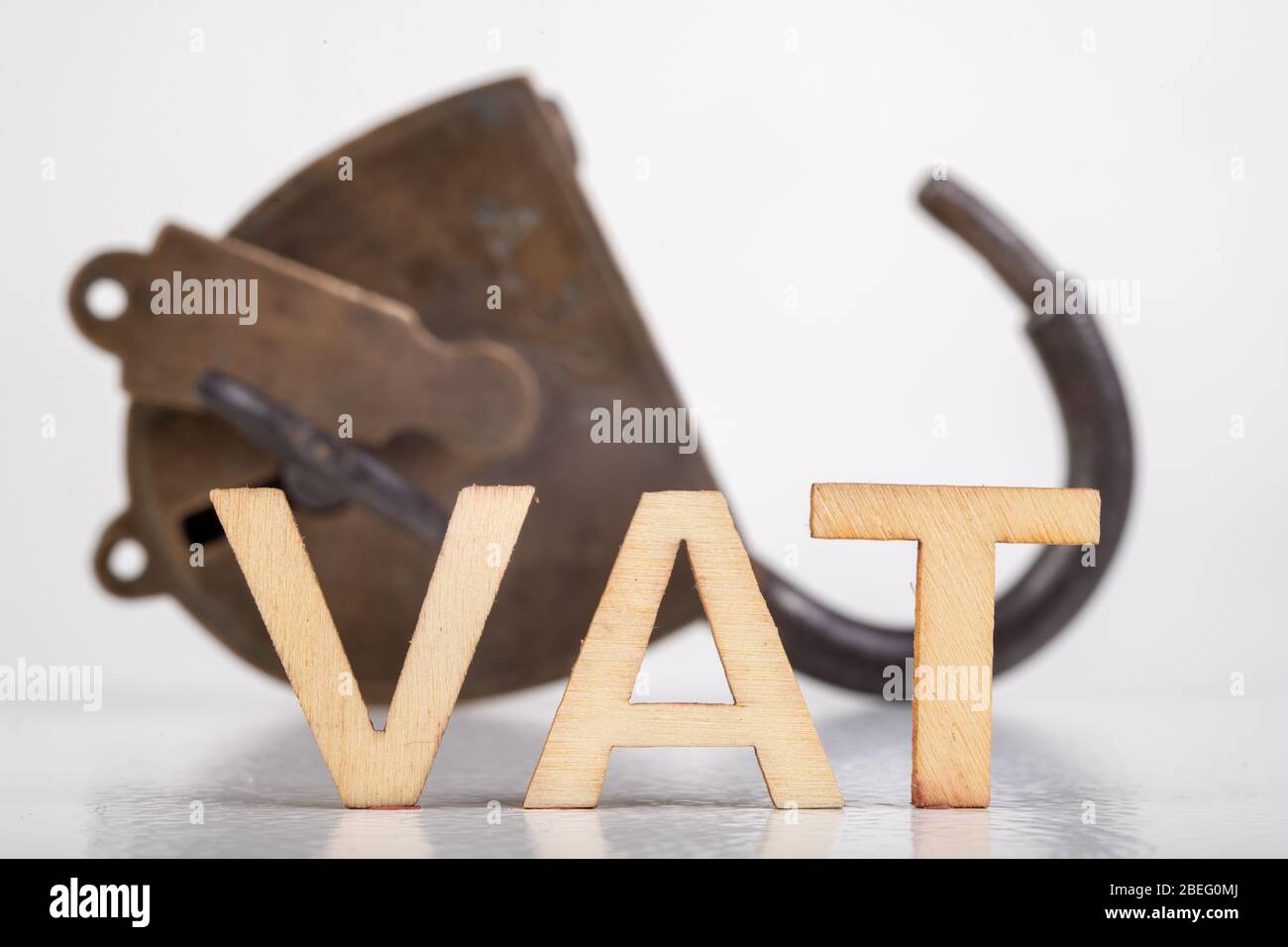 The inscription VAT made of wooden letters. Taxes and an old padlock ...