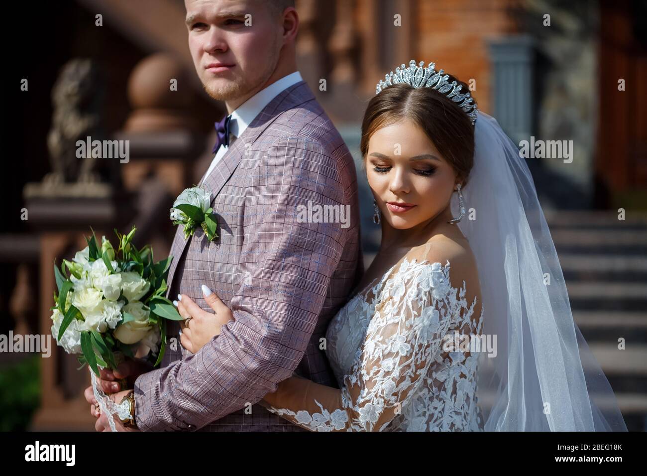 The bride in a white wedding dress and groom in a suit on the ...