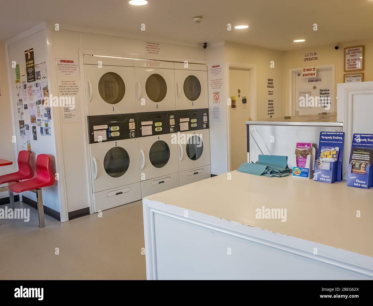Tumble driers and laundry equipment inside an empty laundrette, an essential and key building, during the 2020 Coronavirus lockdown Stock Photo