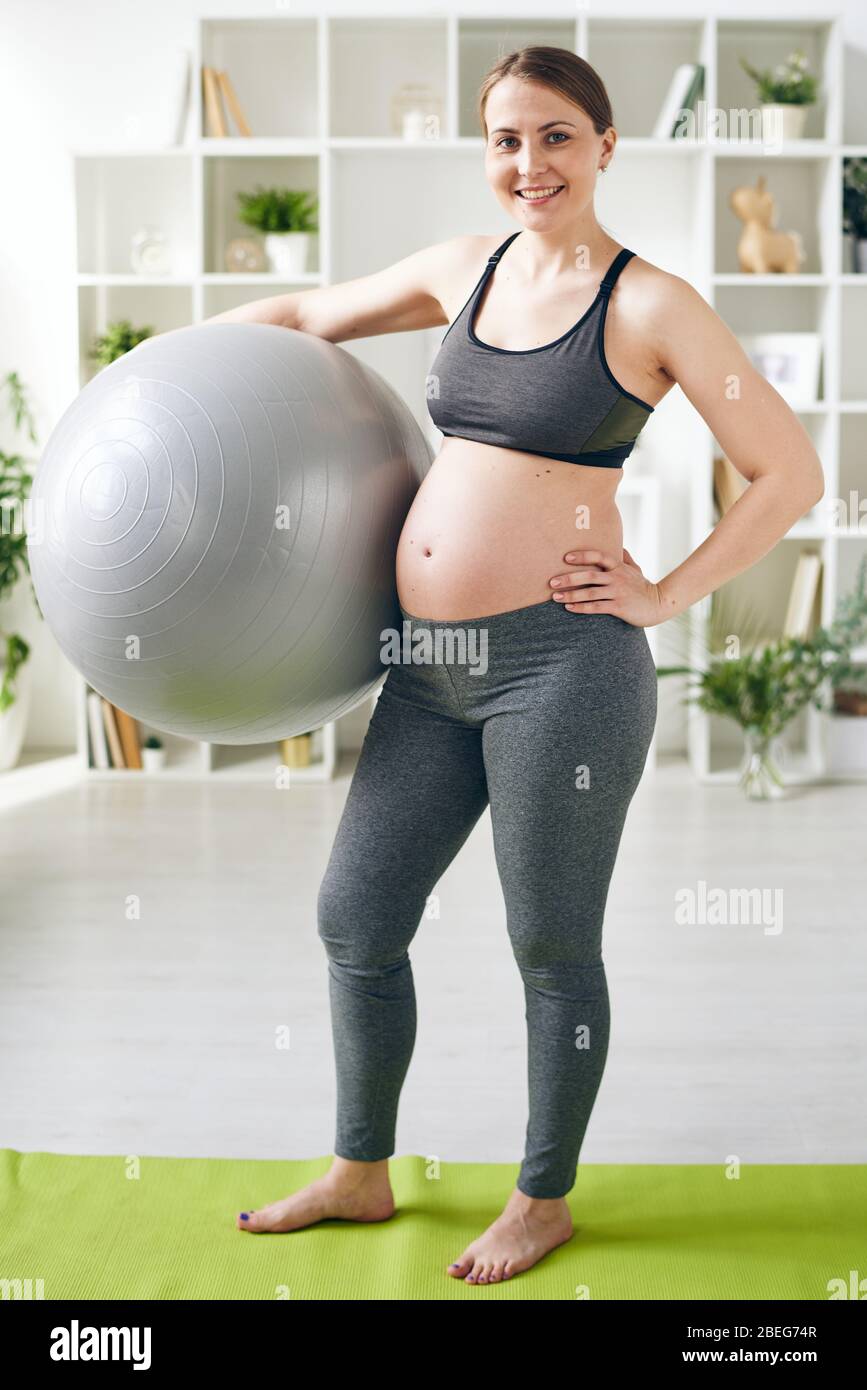 Pregnant woman in sports bra using smart phone in doorway at home Stock  Photo - Alamy