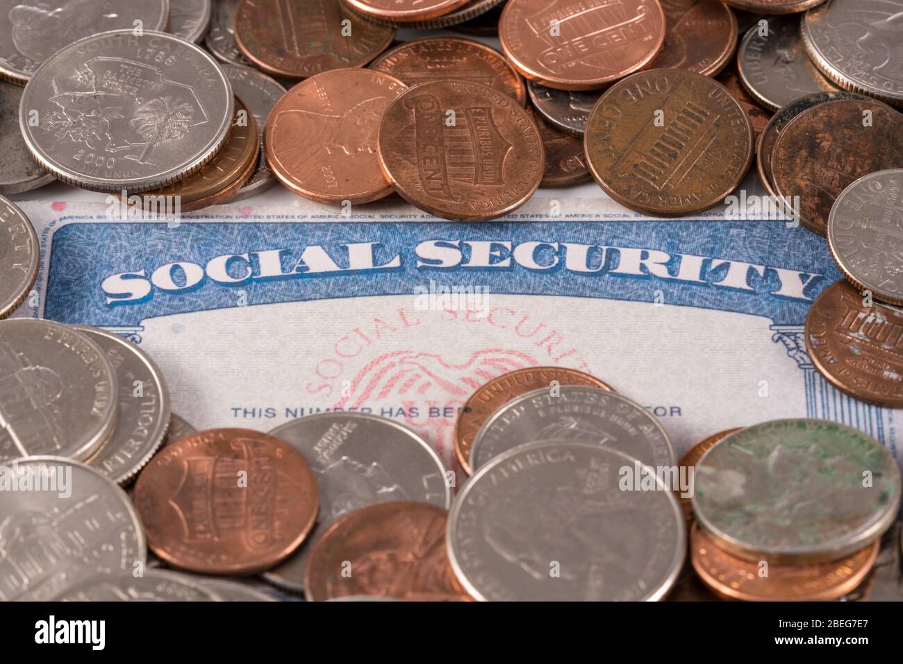 USA social security card with coins and cash to show funding crisis in the trust fund Stock Photo