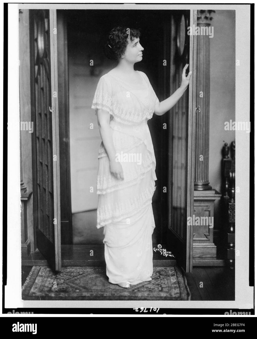 Helen Keller, full-length portrait, standing at door in room, facing ...