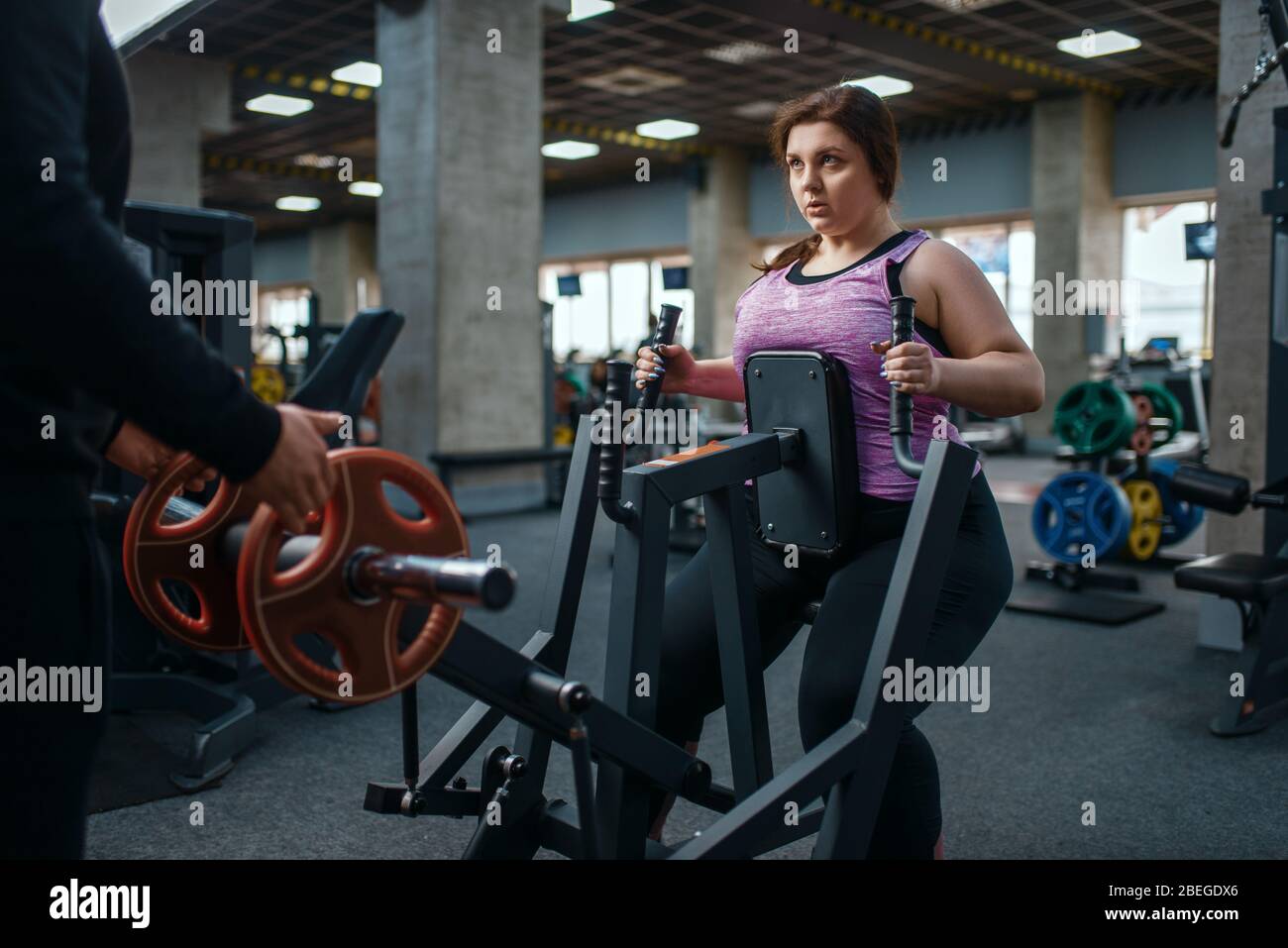 Overweight woman on exercise machine in gym Stock Photo Alamy