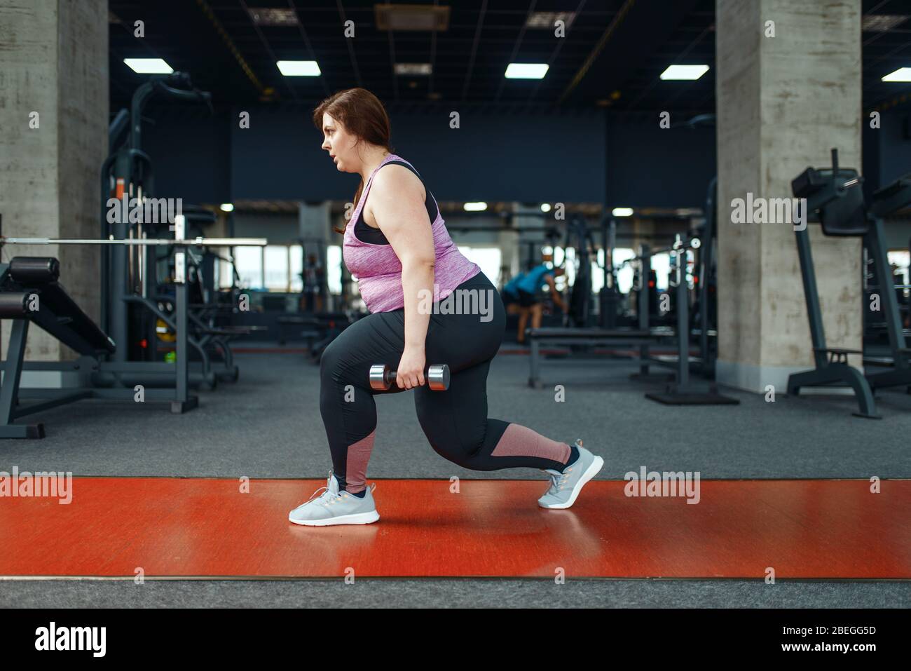 Overweight woman, exercise with dumbbells in gym Stock Photo Alamy
