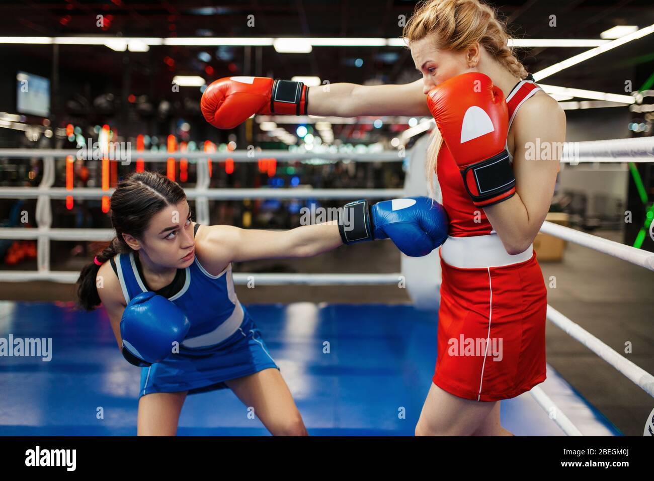 Women in red and blue gloves boxing on the ring Stock Photo