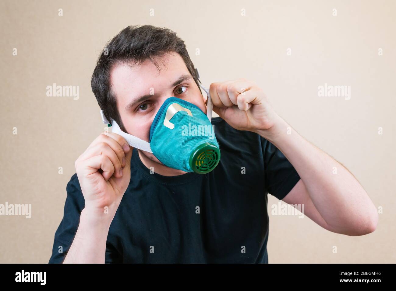 Young man in protective respirator mask during self-isolation and quarantine. Stay home Stock Photo