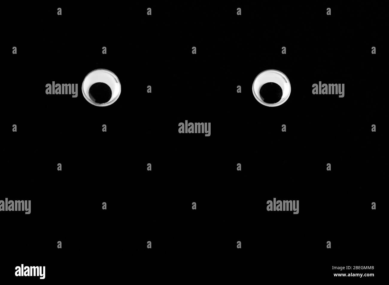 Pair of plastic toy eyes isolated on the black background Stock Photo
