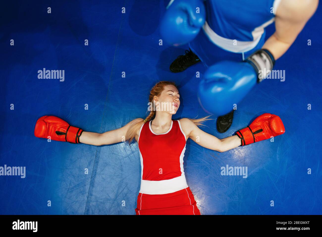 Women boxing, girl in red is knocked out Stock Photo