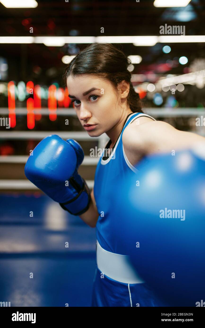 Woman in blue boxing gloves hits in camera Stock Photo