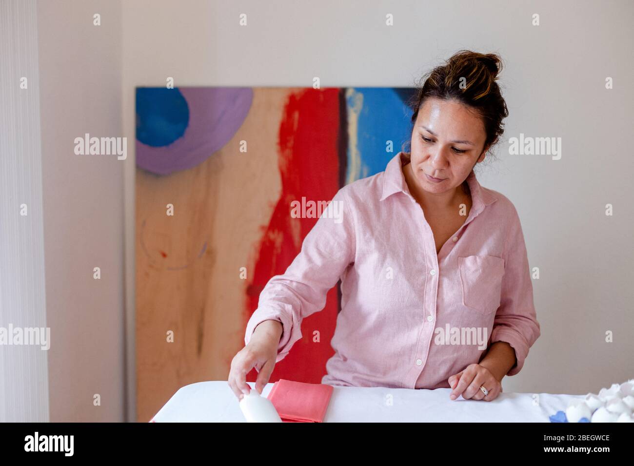 Smiling woman organizing material on table from home studio Stock Photo