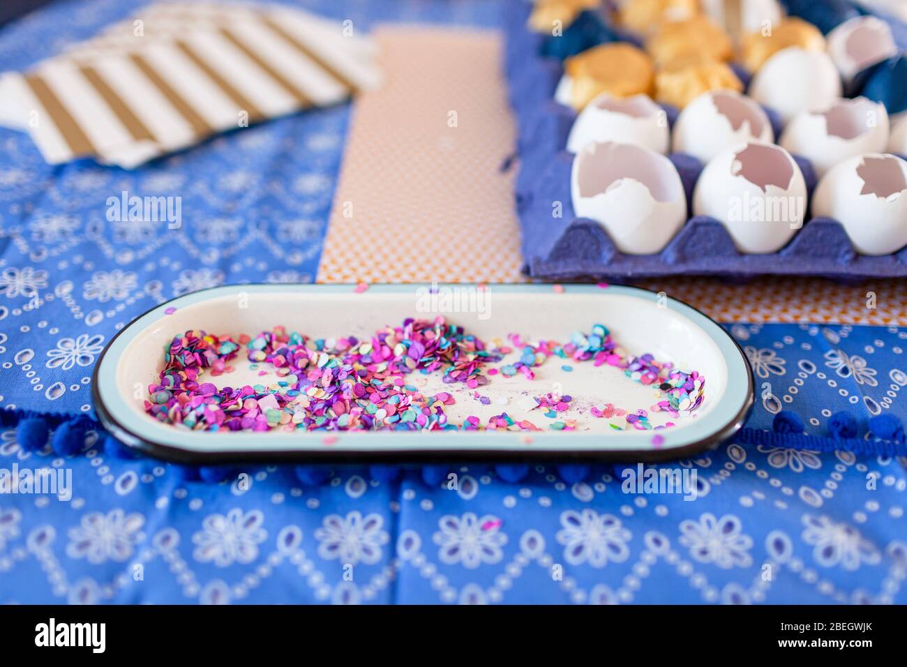 Close-up multi color confetti and eggshells over cloth table Stock Photo