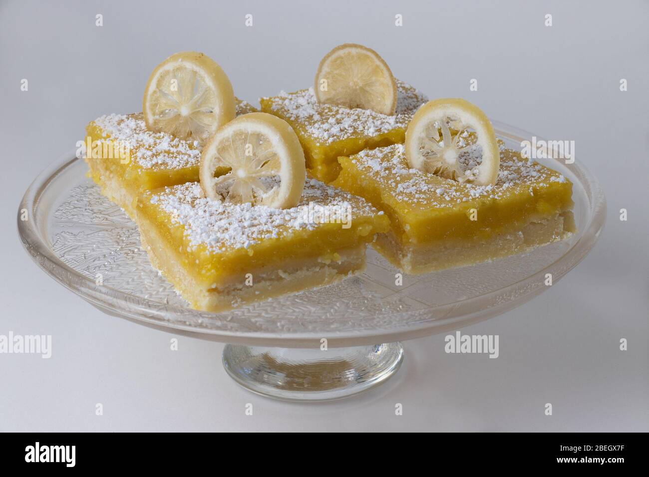 Homemade baked lemon bars topped with sliced lemons and powdered sugar Stock Photo