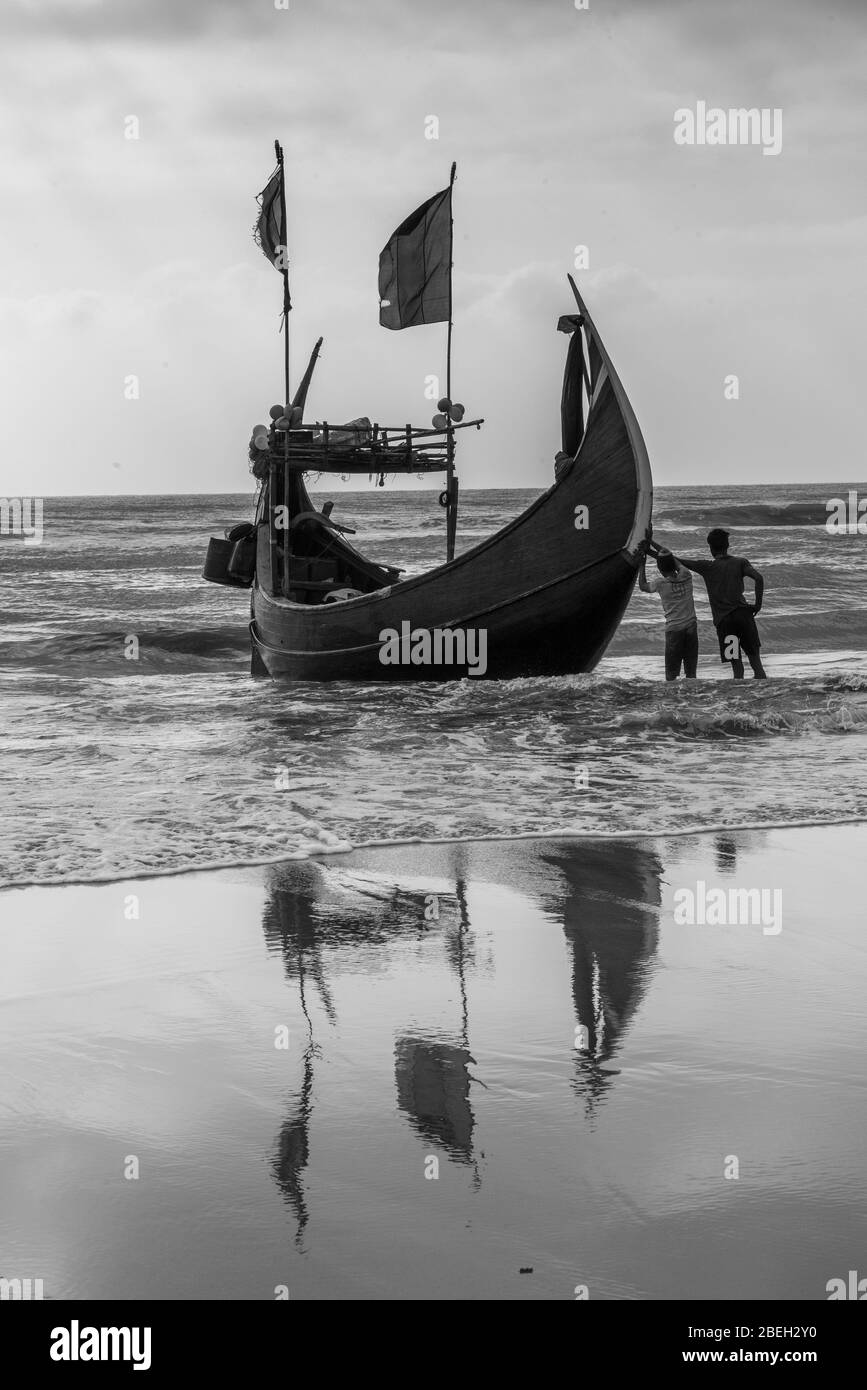 Men Hauling Moon Shaped Fishing Boats in a Fishing Village South of Cox's Bazar Stock Photo