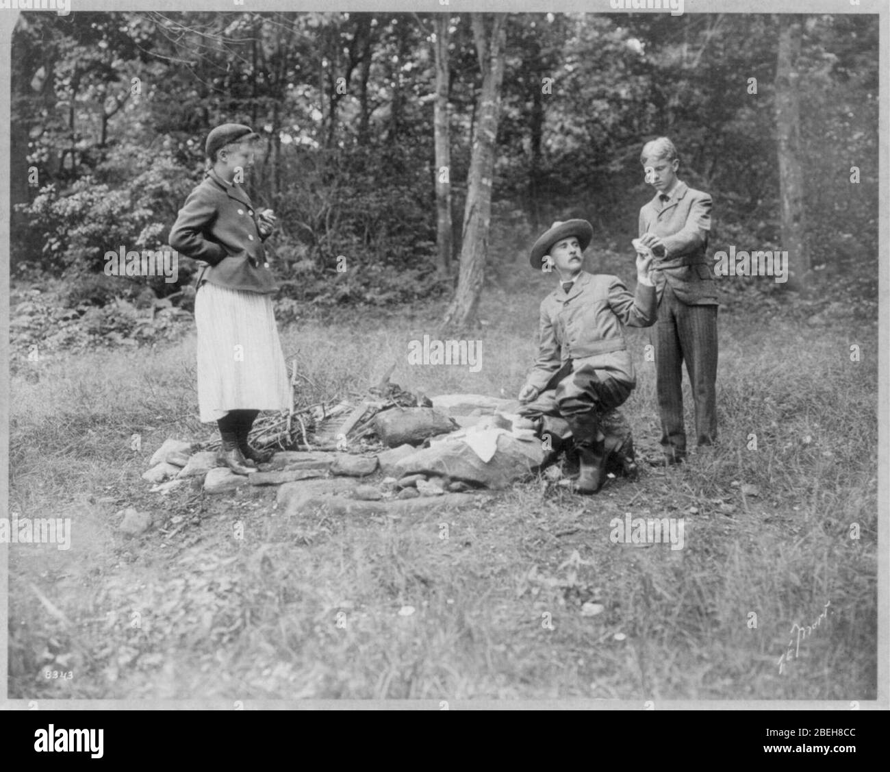 Henry Van Dyke and 2 others with sandwiches at campfire Stock Photo
