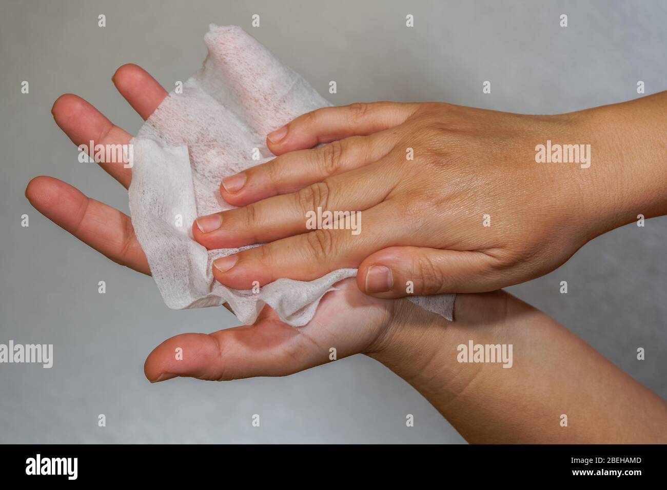 Effective cleaning hands with alcohol-based hand sanitizing antiseptic wipes. Female holds pre-moistened, soft textured wipe & rubs it as disinfectant Stock Photo