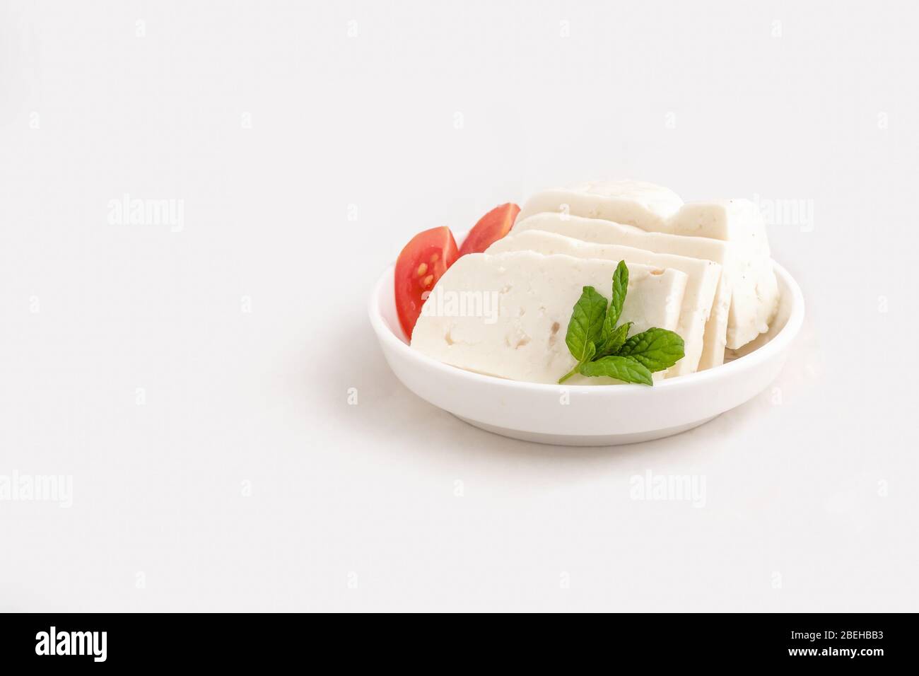 Halloumi cheese in white bowl Stock Photo