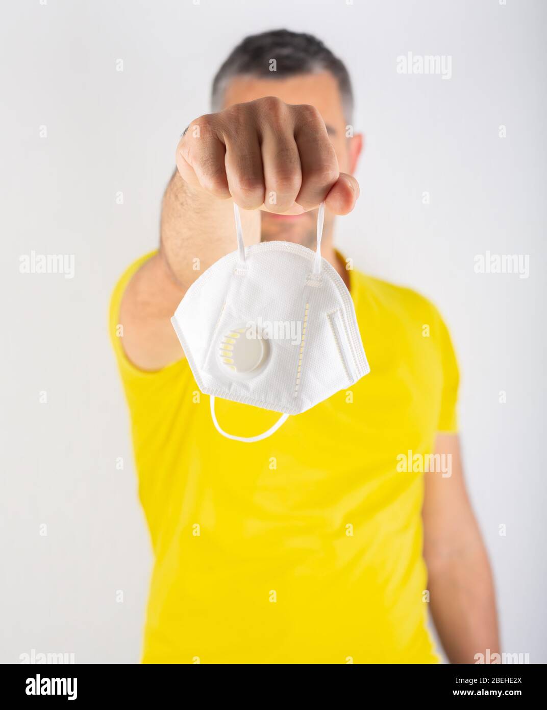 Download A Man In Yellow T Shirt Holds Medical Mask Coronavirus Concept Protect Your Health Stock Photo Alamy PSD Mockup Templates