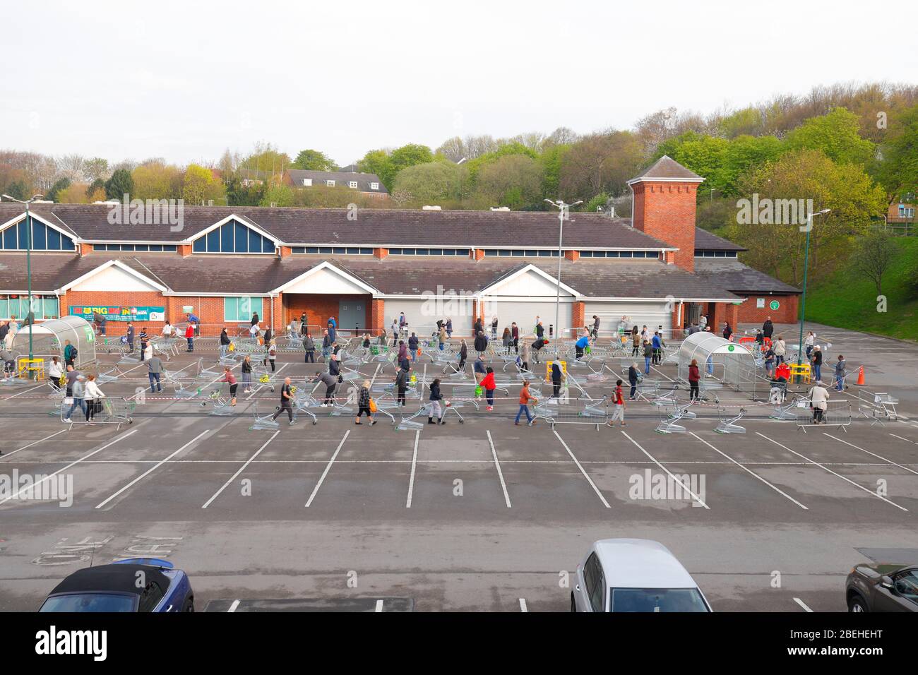 Shoppers at Asda Killingbeck queue on a one way system designed to maintain social distancing