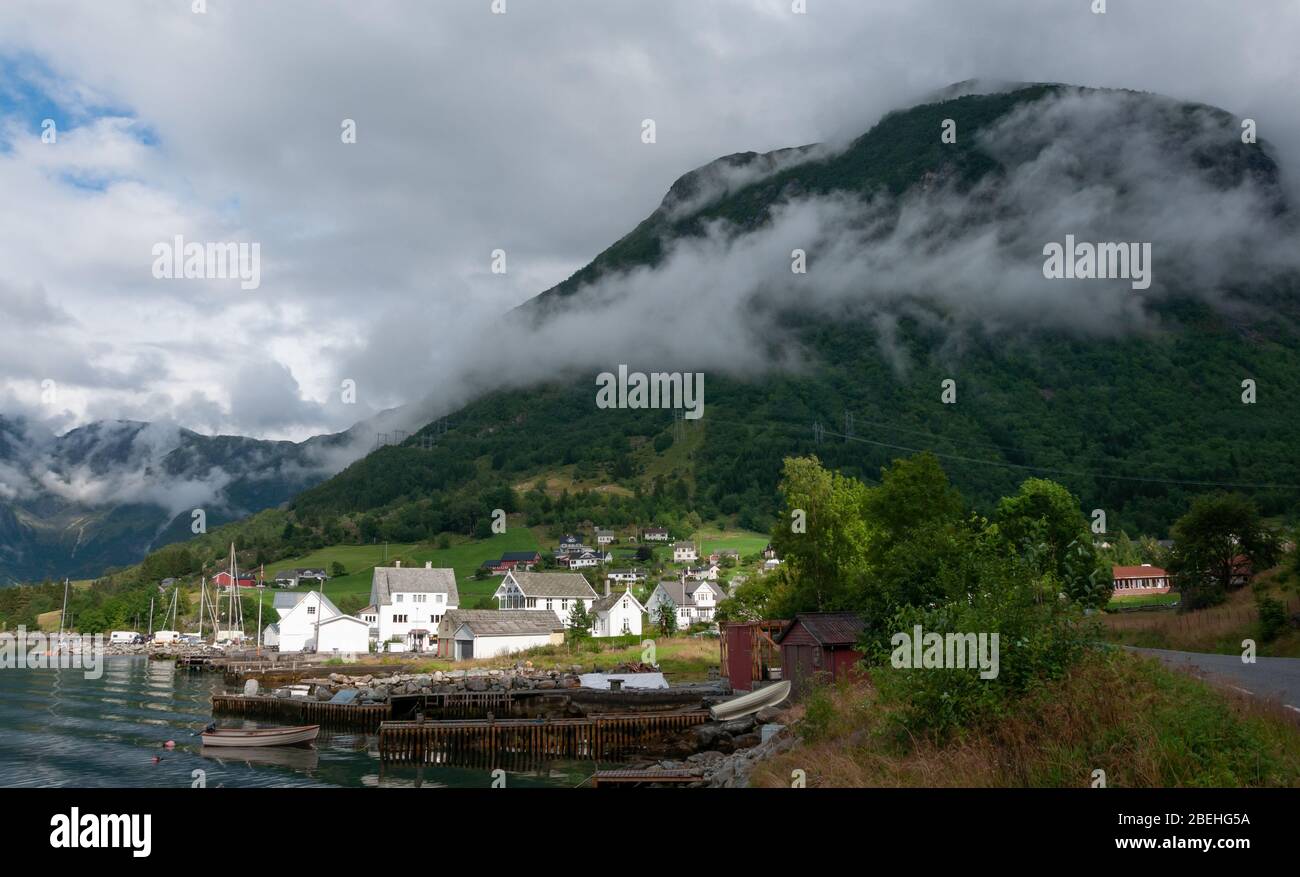 Peaceful village, lake, mountains and boats Stock Photo