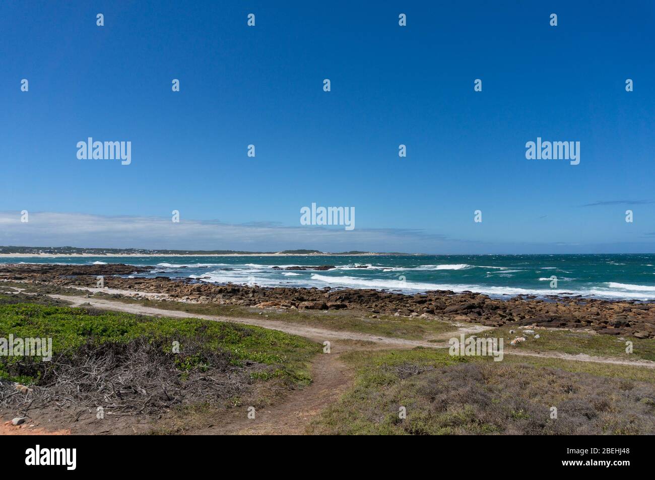 Ocean landscape with beach in the distance and clear sky on sunny day ...