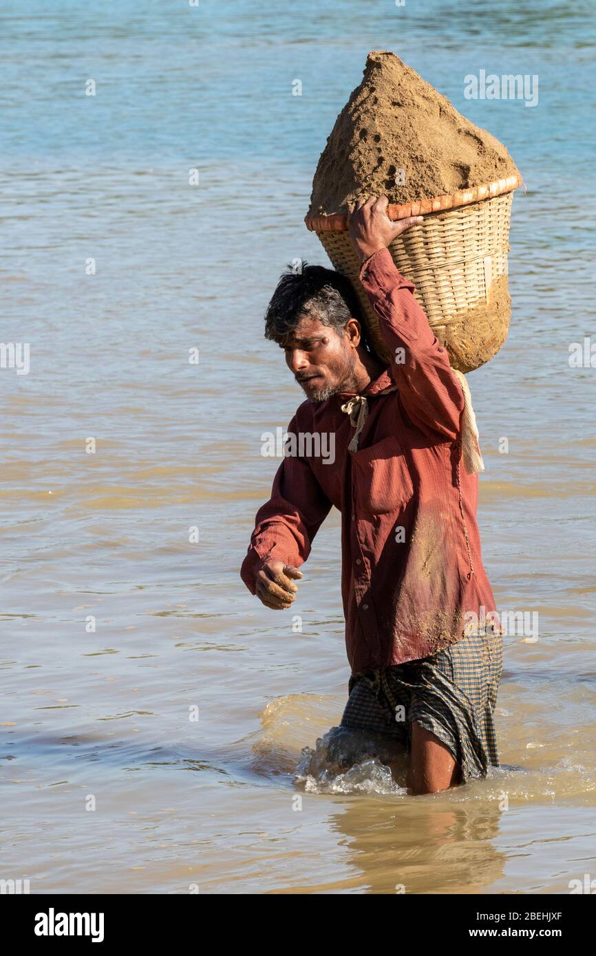 Worker Carrying A Bucket Of Sand Dug out From The Shari-Goyain River To Make Concrete, Sylhet, Bangladesh Stock Photo
