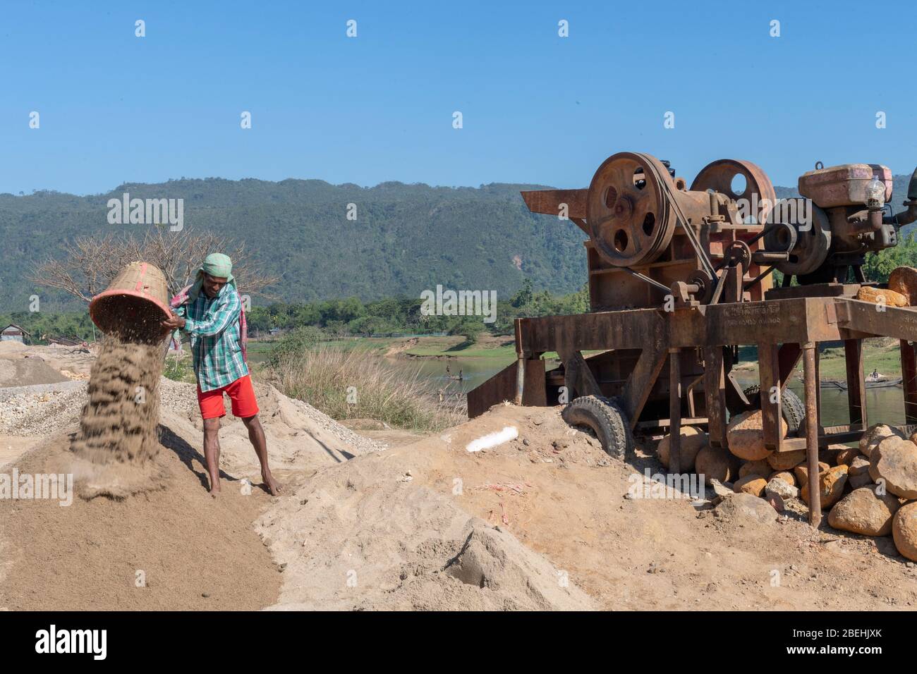 Worker Emptying Sand Bucket Dug Out from The Shari-Goyain River To Make Concrete, Sylhet, Bangladesh Stock Photo