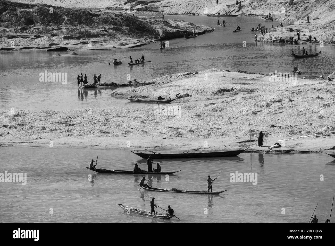 Workers with Boats For Digging Out Gravel from the Goyain River in Jaflong, at the border with India. The gravel will be sieved to make concrete. Stock Photo
