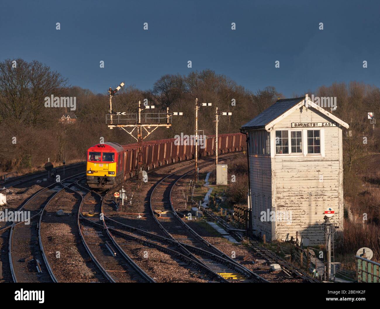 DB cargo Rail UK class 60 locomotives passing the semaphore bracket railway signals and mechanical signal box at Barnetby east with a freight train Stock Photo