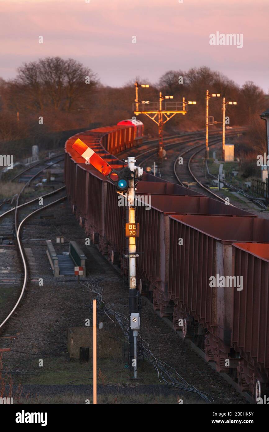 Freight train passing a upper quadrant mechanical semaphore home signal at Barnetby East with a bracket signal behind. Stock Photo