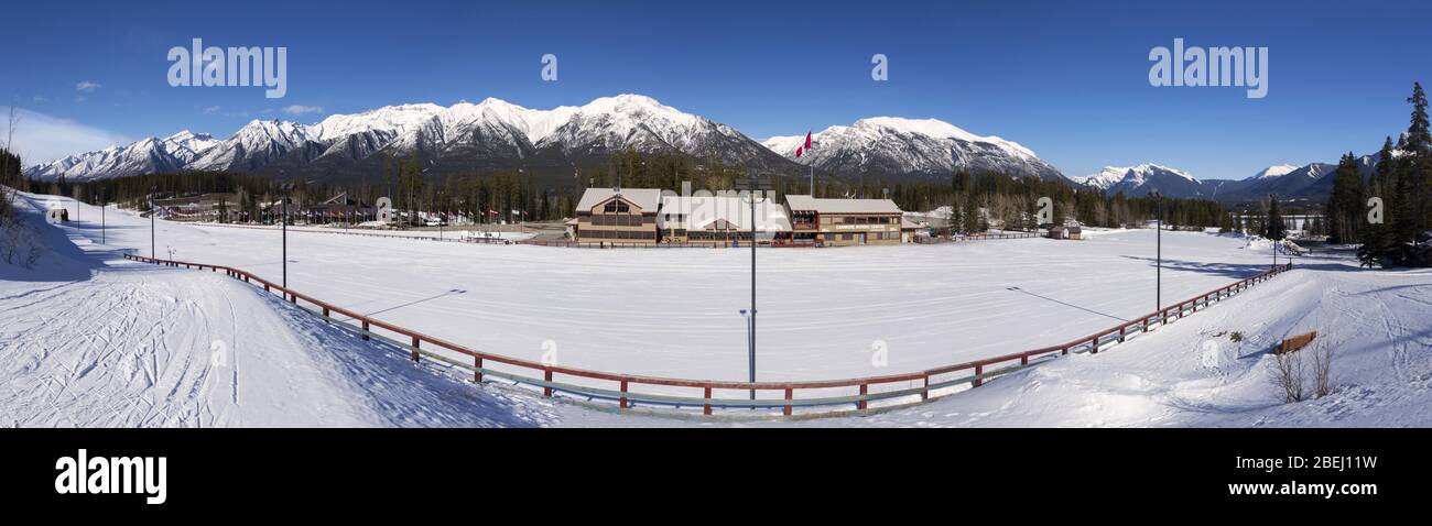 Sunny Springtime Panoramic Landscape Canmore Nordic Centre Alberta Provincial Park Canadian Rocky Mountains with Groomed Cross Country Ski Runs Stock Photo
