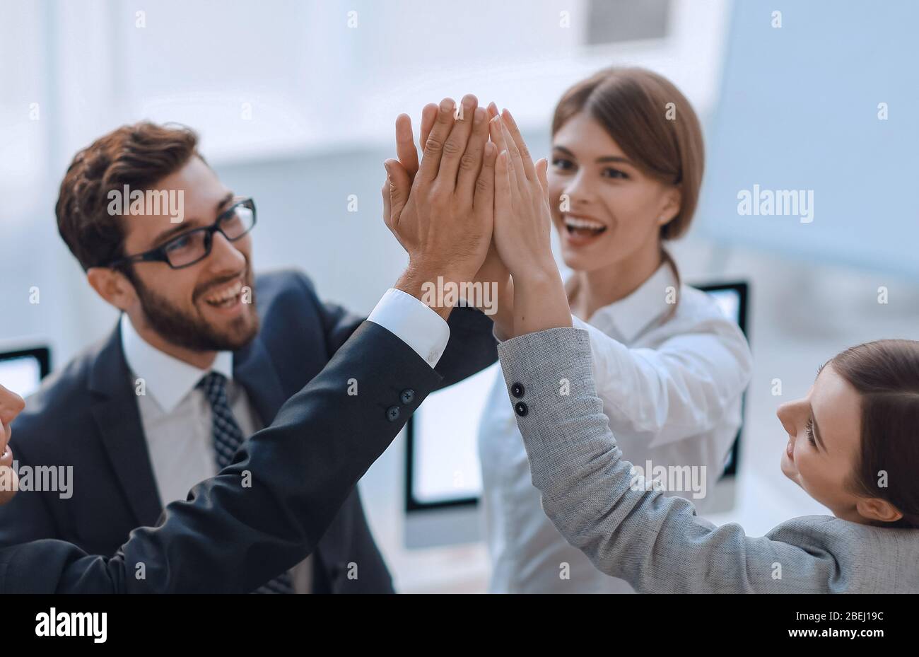 successful business team giving each other a high-five, standing in the ...