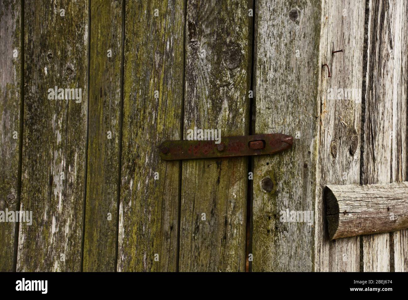 Detail of the old wooden door with a rusty metal lock Stock Photo