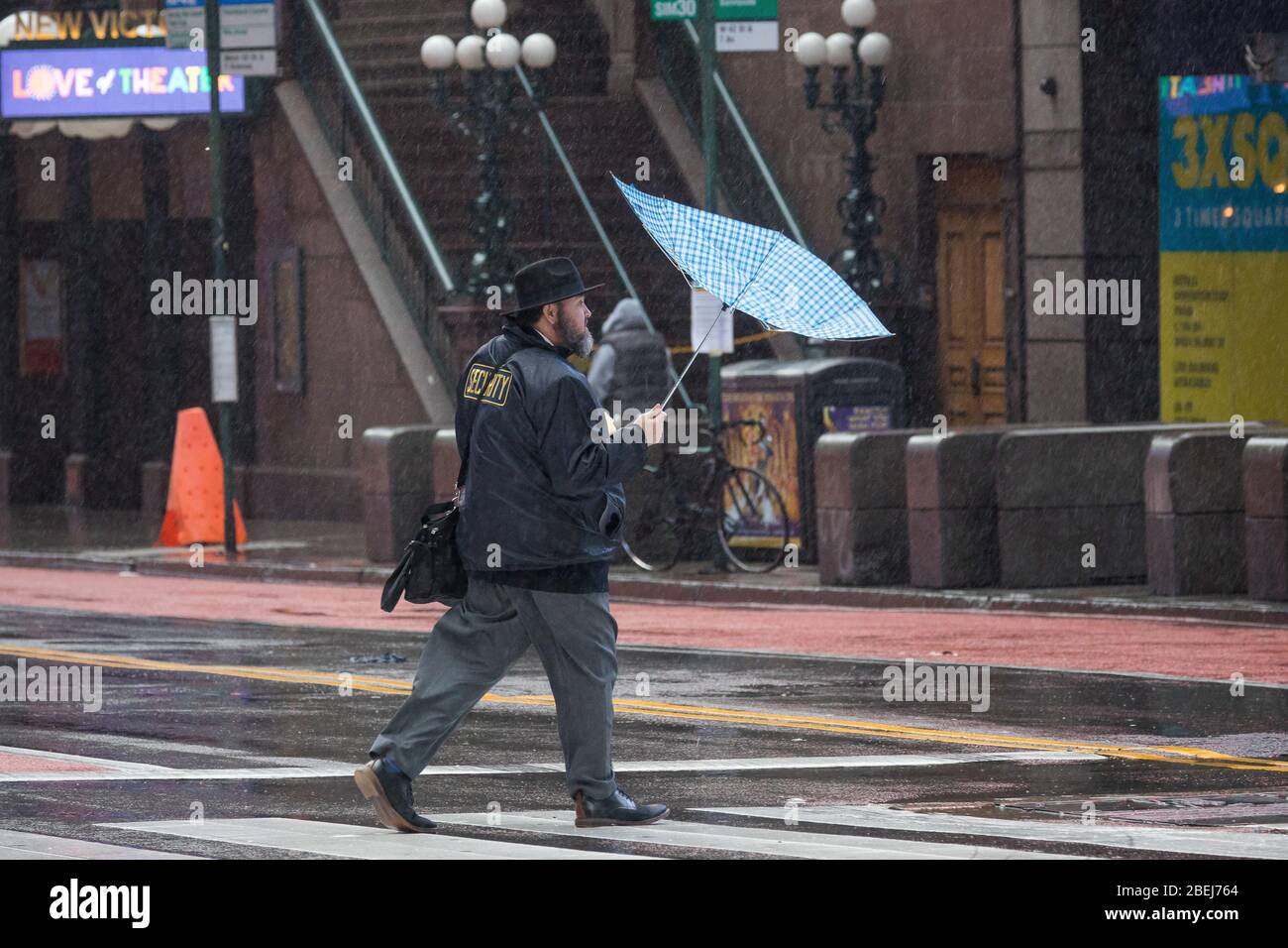 New York, USA. 13th Apr, 2020. A pedestrian carrying an umbrella walks against the wind at the Times Square neighborhood in New York, the United States, April 13, 2020. Strong wind and rain hit New York on Monday. Credit: Michael Nagle/Xinhua/Alamy Live News Stock Photo