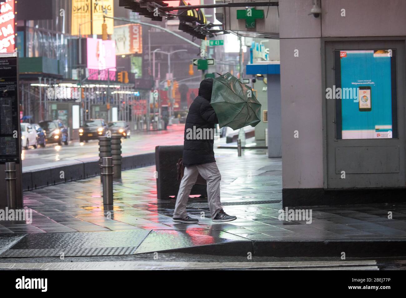 New York, USA. 13th Apr, 2020. A pedestrian carrying an umbrella walks against the wind at the Times Square neighborhood in New York, the United States, April 13, 2020. Strong wind and rain hit New York on Monday. Credit: Michael Nagle/Xinhua/Alamy Live News Stock Photo