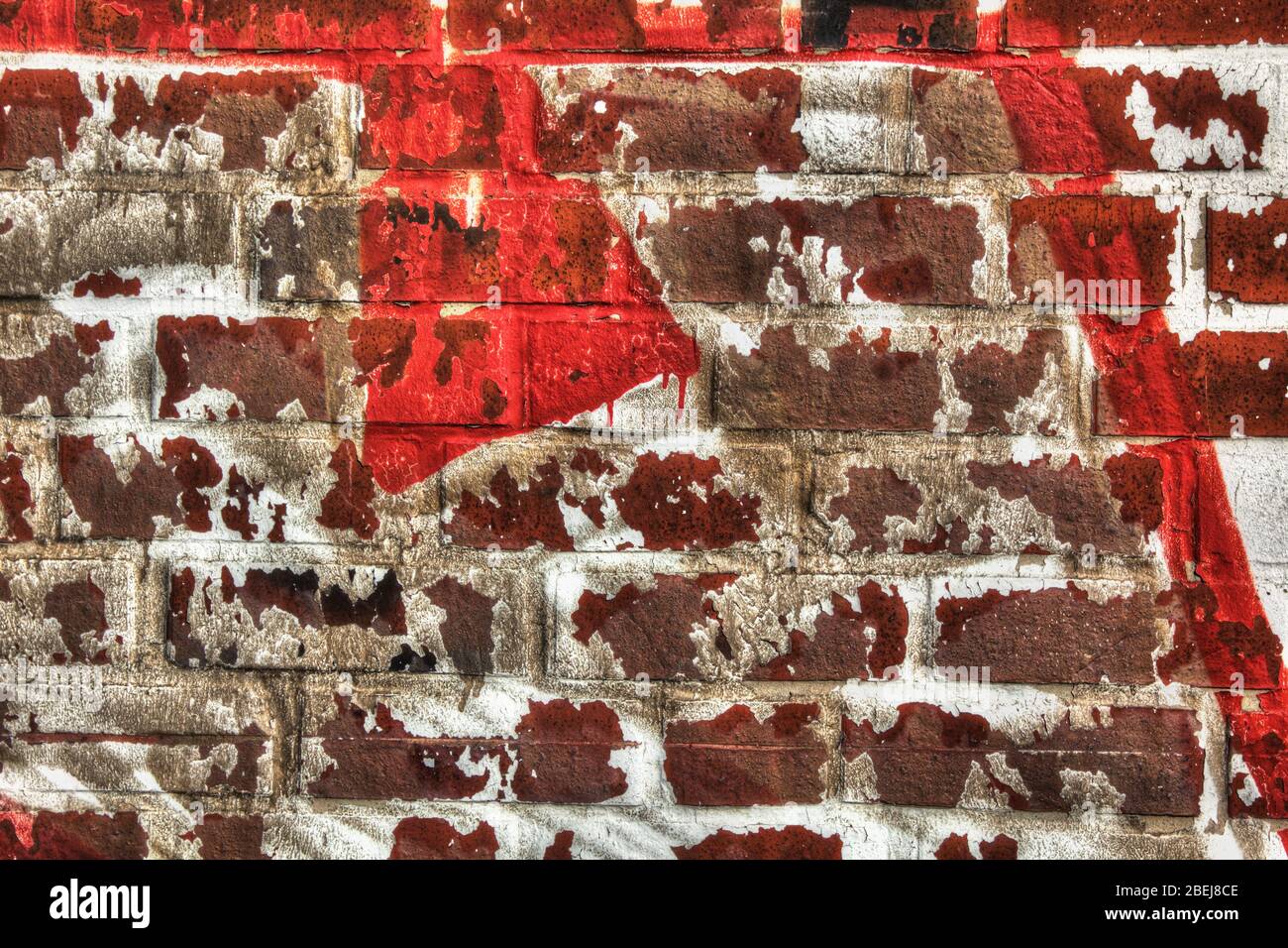 Wall of red bricks with rest of white color. Stock Photo