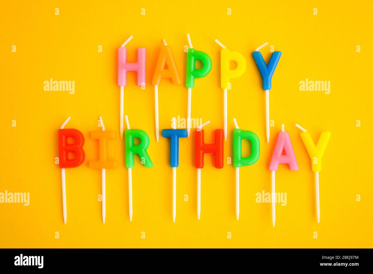 Happy Birthday candles on yellow background. Bright color wallpaper