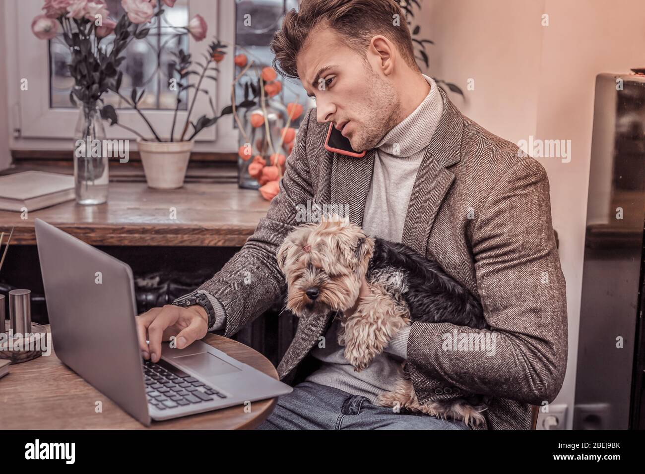 Portrait of a busy hardworking man sitting in cafe with dog on a good day Stock Photo