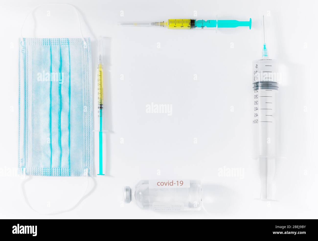 Coronavirus vaccine , COVID-19, 2019-nCov novel coronavirus concept. Creative composition with syringes, phial and disposable medical mask. Flat lay Stock Photo