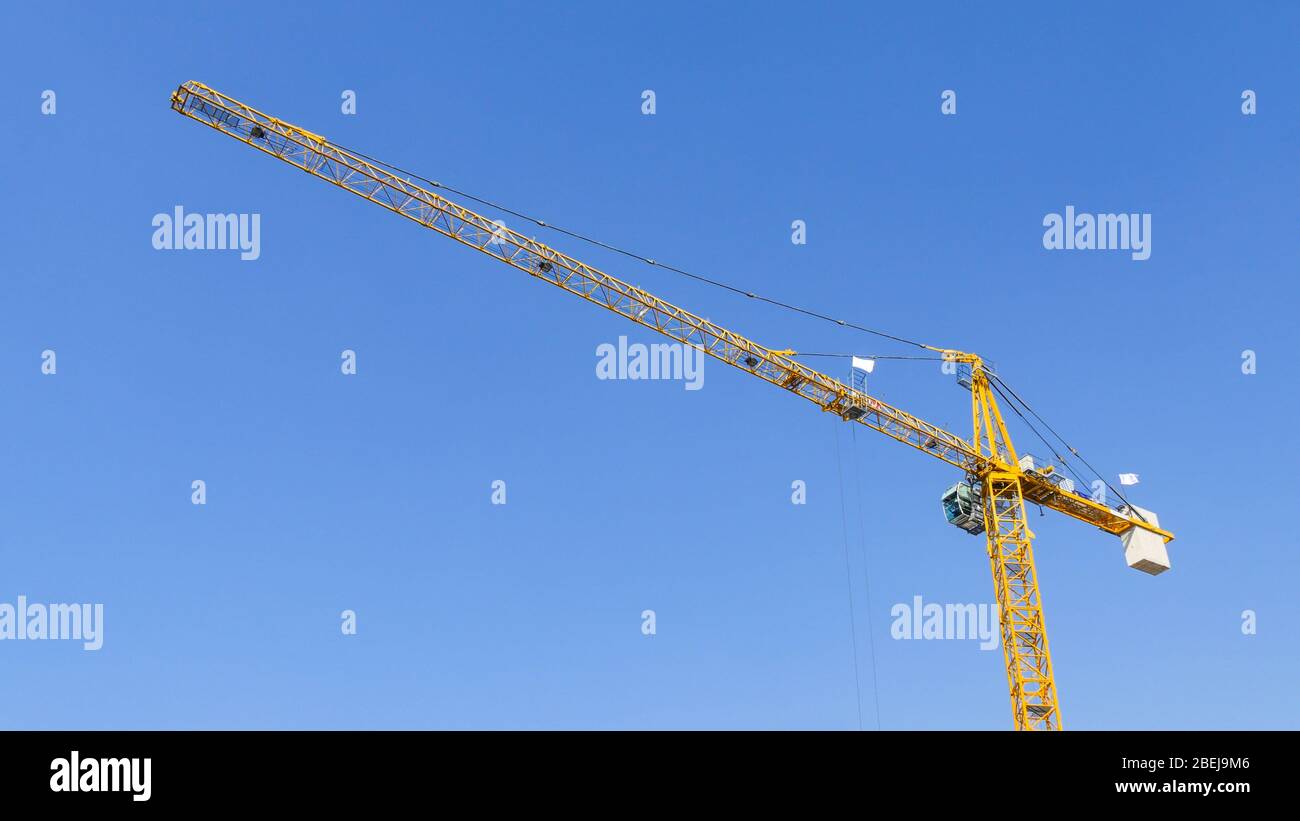 Construction crane against a clear sky. Building industry. Stock Photo