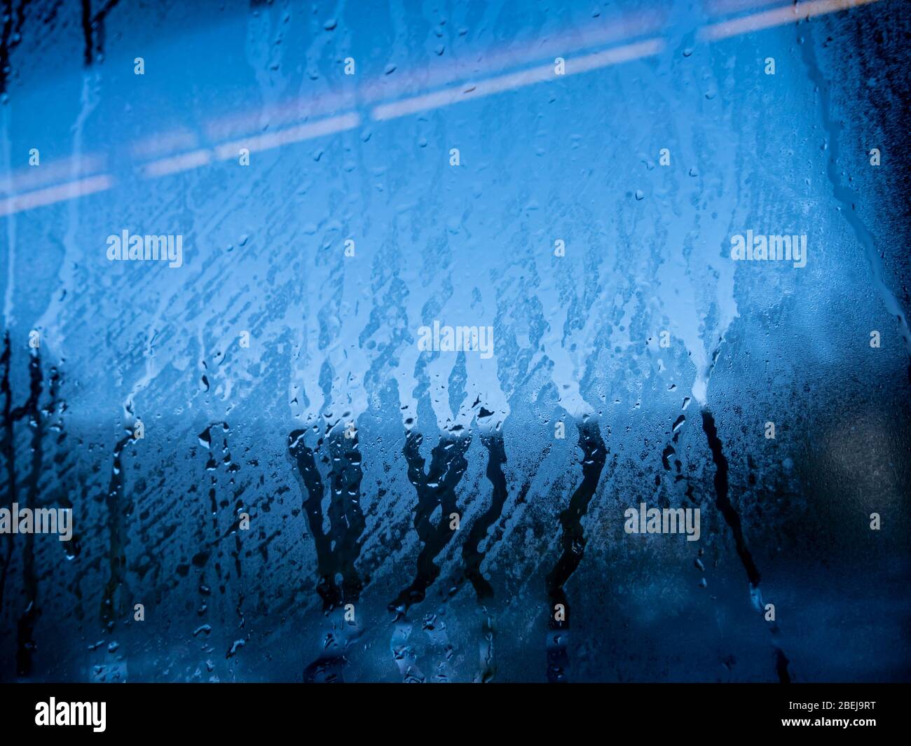 Condensation water drop on the blue glass window. Rain. Abstract background texture. Stock Photo