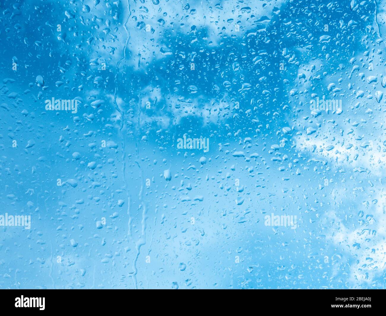 Wet window with rain drops and a cloudy sky outside background Stock Photo  - Alamy