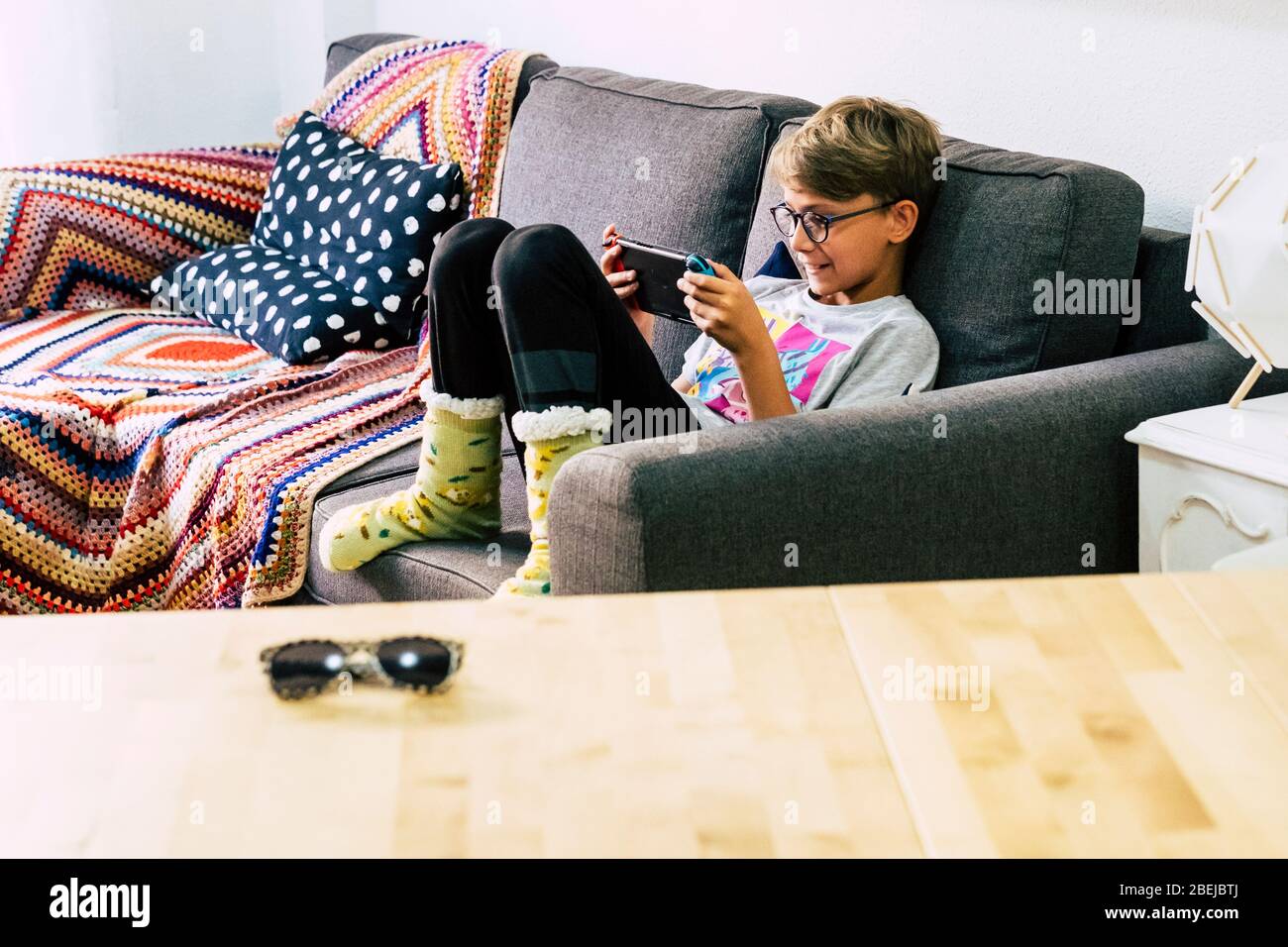 Lonely young caucasian children at home playing with technology videogames portable device with online connected friends - modern teeanger and esport Stock Photo