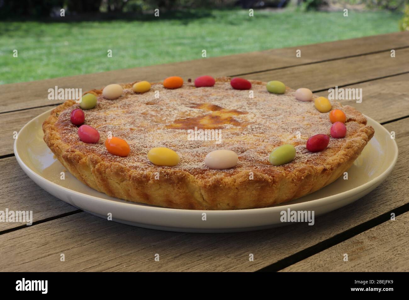 Traditional rice pudding Easter cake decorated with sugar eggs. Side view. Wooden table. Stock Photo