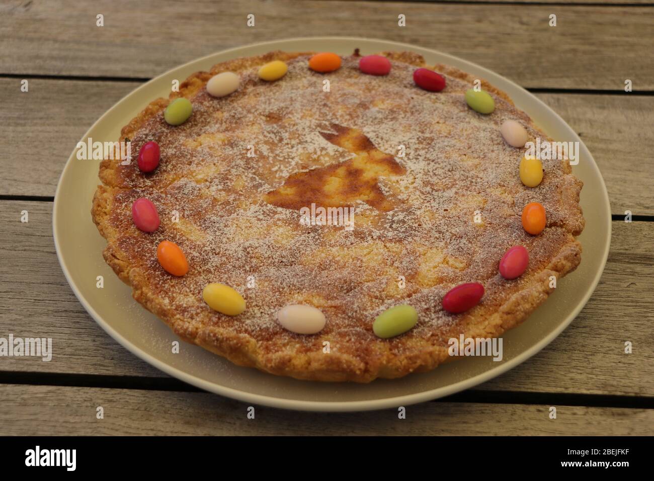 Traditional rice pudding Easter cake decorated with sugar eggs. Top view. Wooden table. Stock Photo