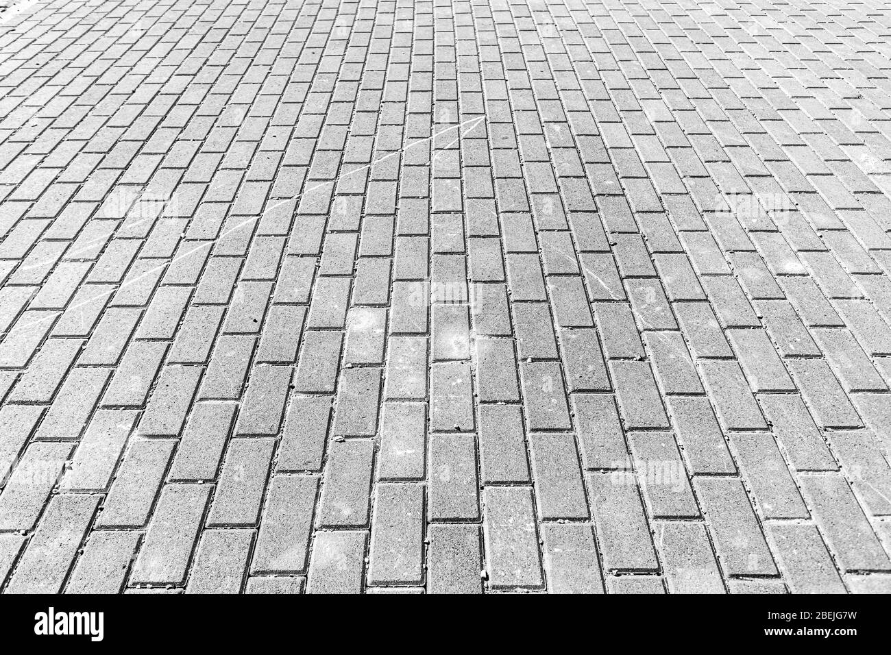 Top view on black and white paving stone road. Old pavement of granite